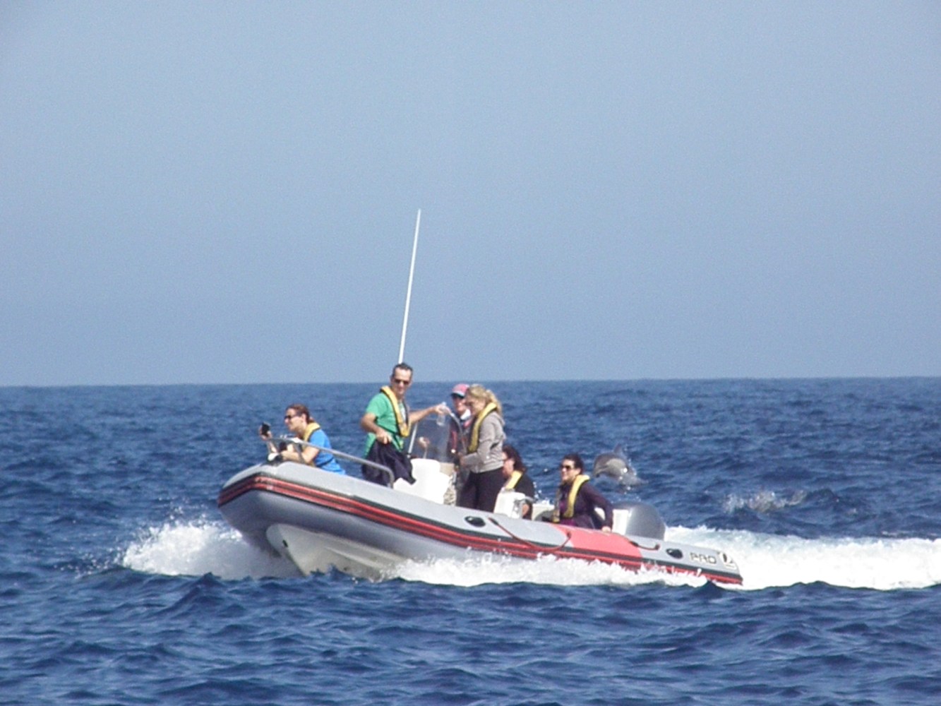 Group of people on a small motorboat in the ocean.